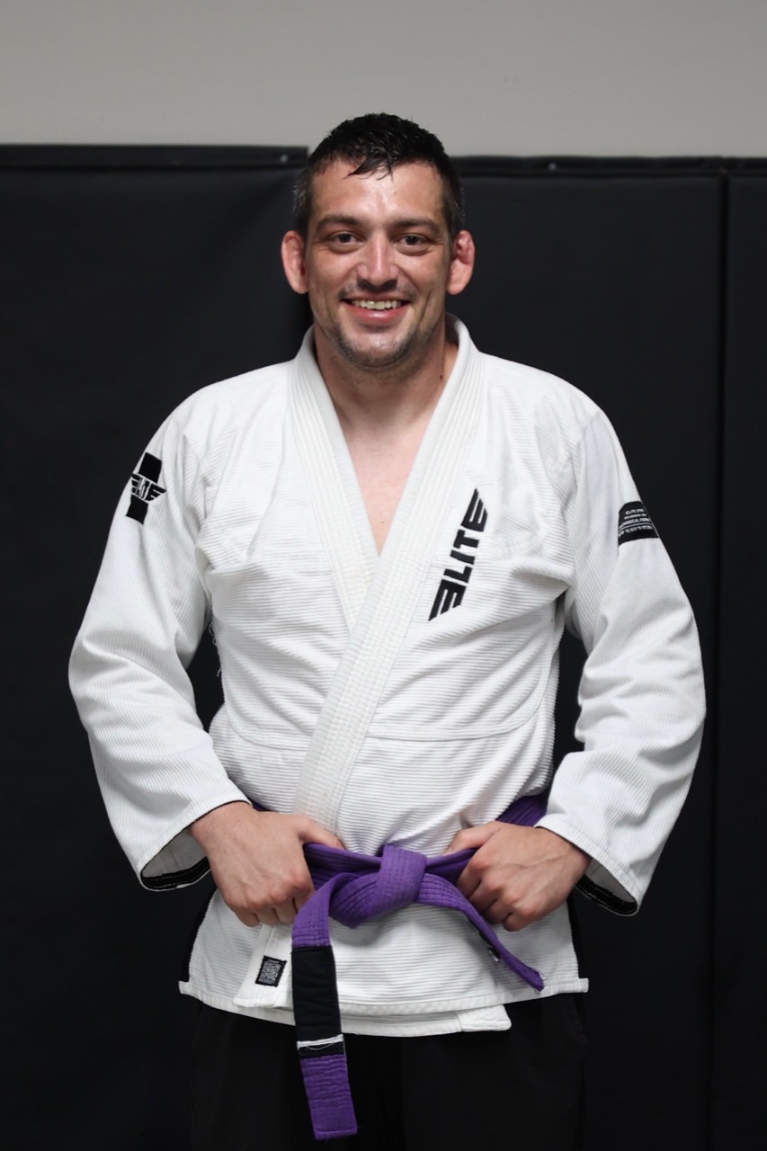 Coach Shane Butters wearing a white gi at Meta Jiu Jitsu Academy