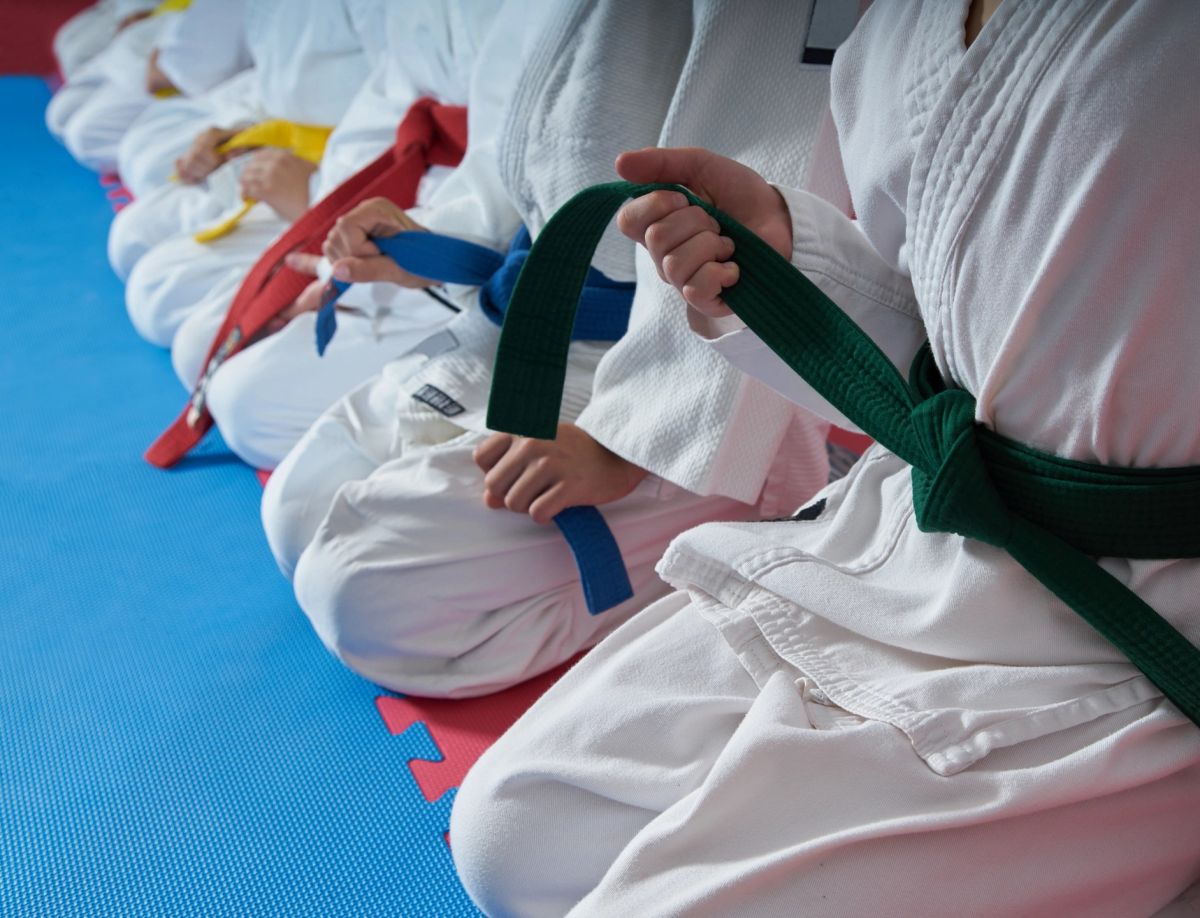 Kids in martial arts uniforms holding belts